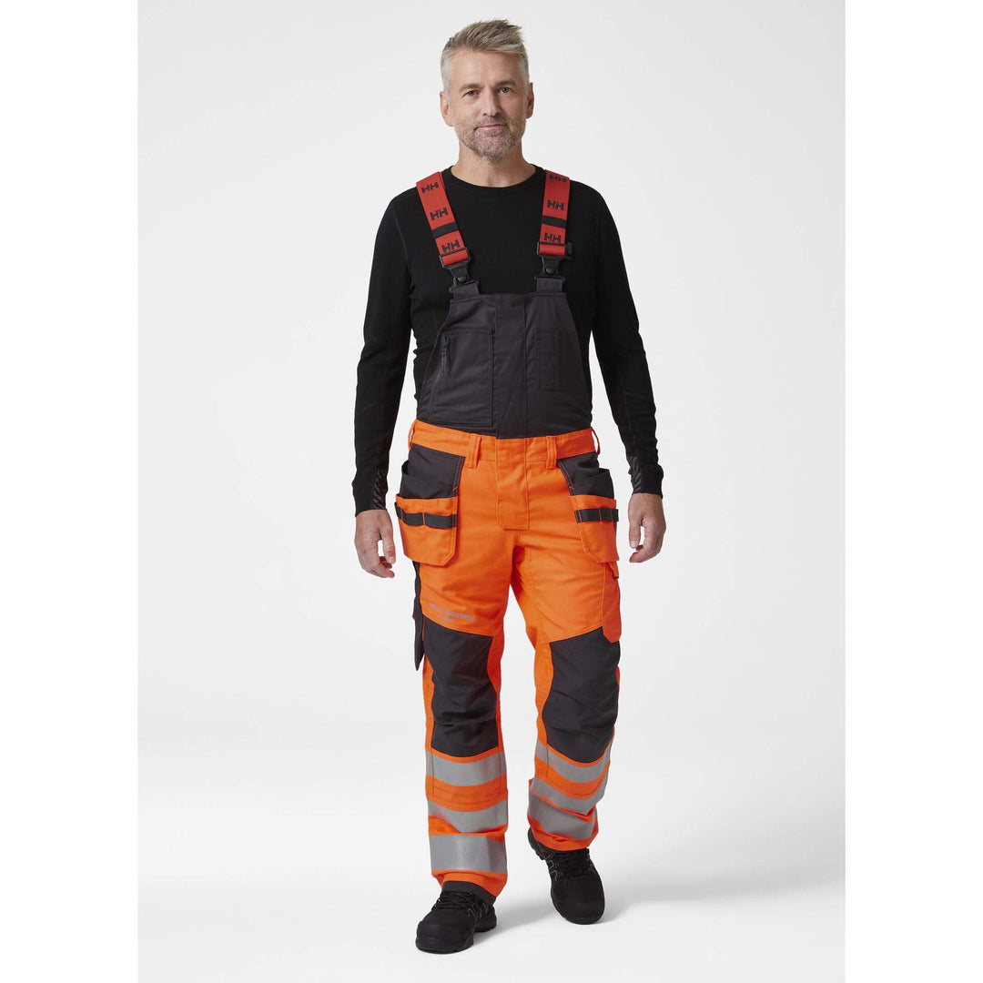 Helly Hansen Alna 2.0 Hi Vis Stretch Construction Bib and Brace Pants Orange/Ebony 3 On Body 1#colour_orange-ebony